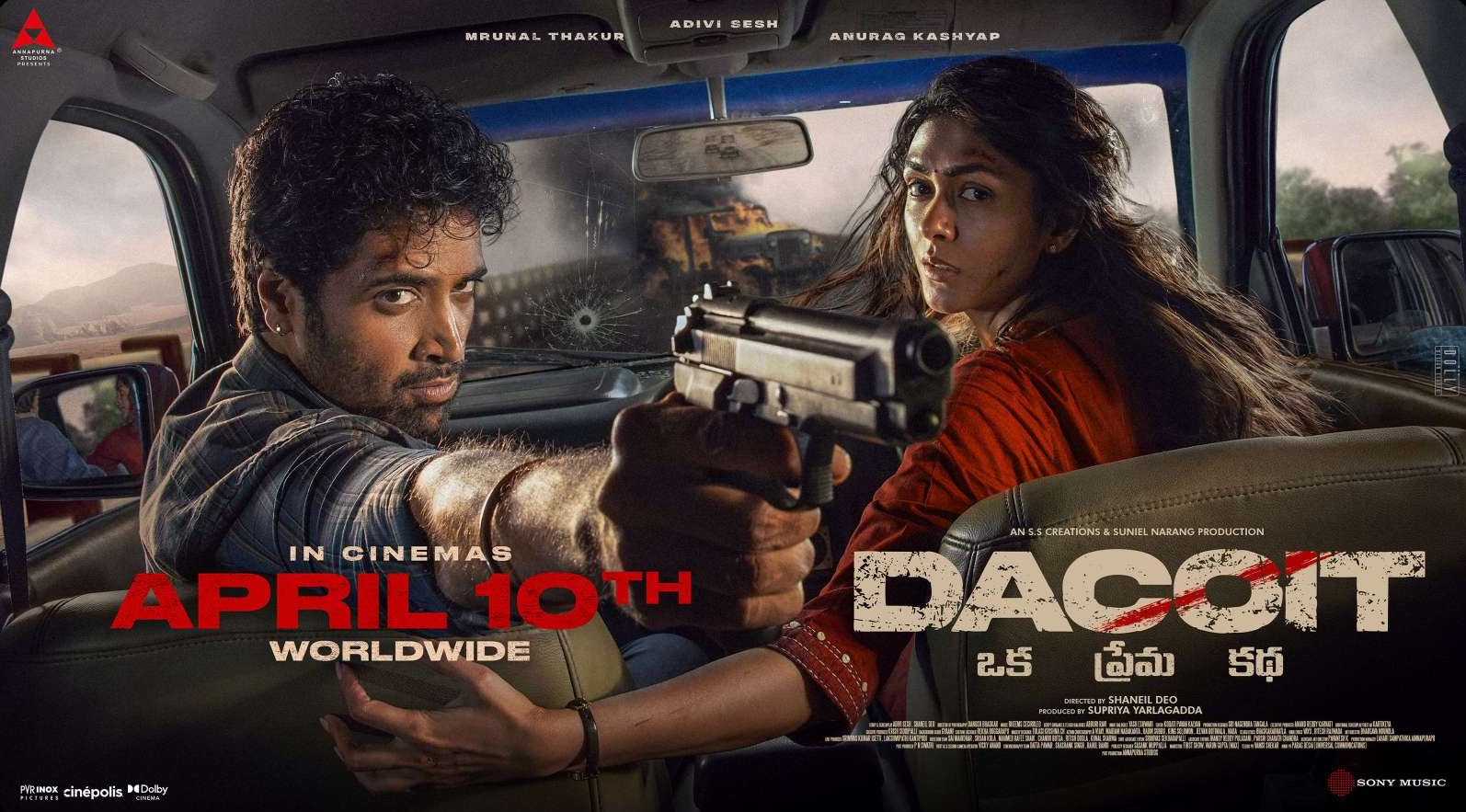 Dacoit release banner — the leads inside a car, gun drawn, ‘April 10th worldwide’